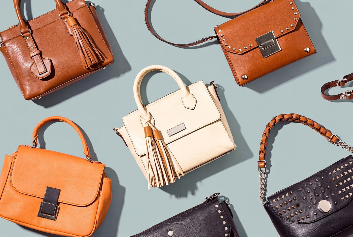 Collection of various leather handbags on a light blue background